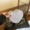 pochette élégante en forme de coquille pour femme avec un design unique et une finition en cuir brillant