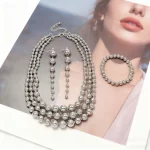 Ensemble de bijoux de luxe en perles d&rsquo;or : collier de déclaration, boucles d&rsquo;oreilles pendantes et bracelet pour femmes élégantes