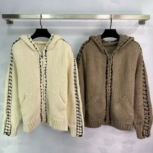 Ce nouveau cardigan décontracté en tricot à capuche comprend des détails crochetés à la main, des rayures décoratives tissées et une fermeture éclair.