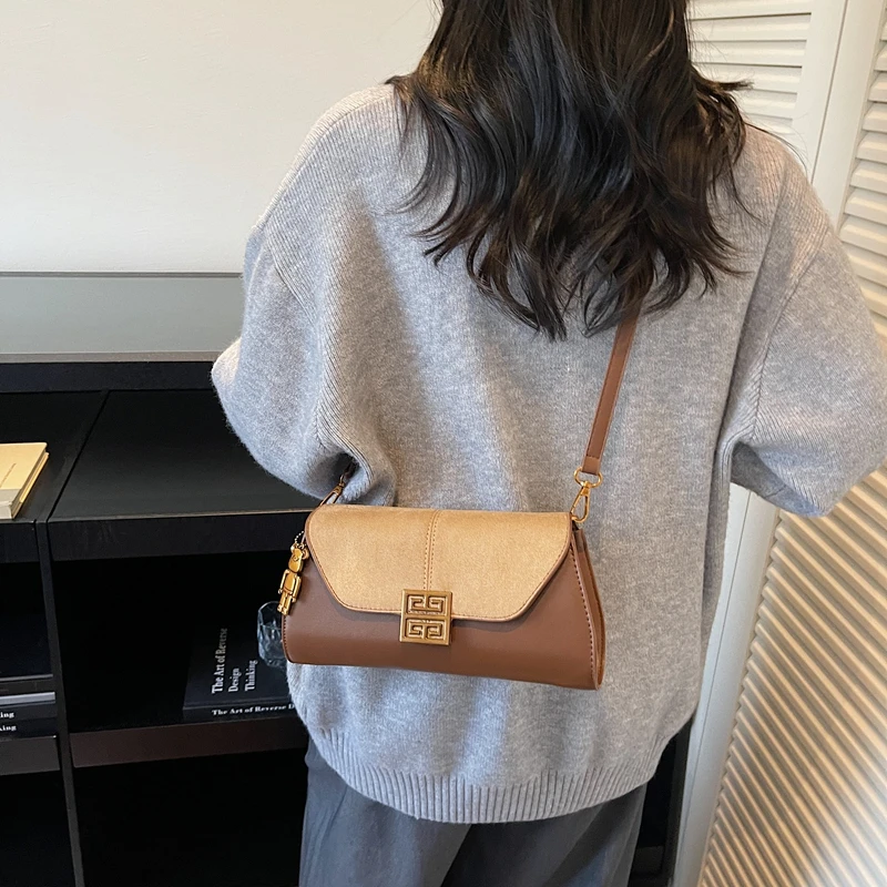 Sac à bandoulière minimaliste courbé, détail au point supérieur raffiné, Silhouette non commune pour les escapades chics, luxe sans effort