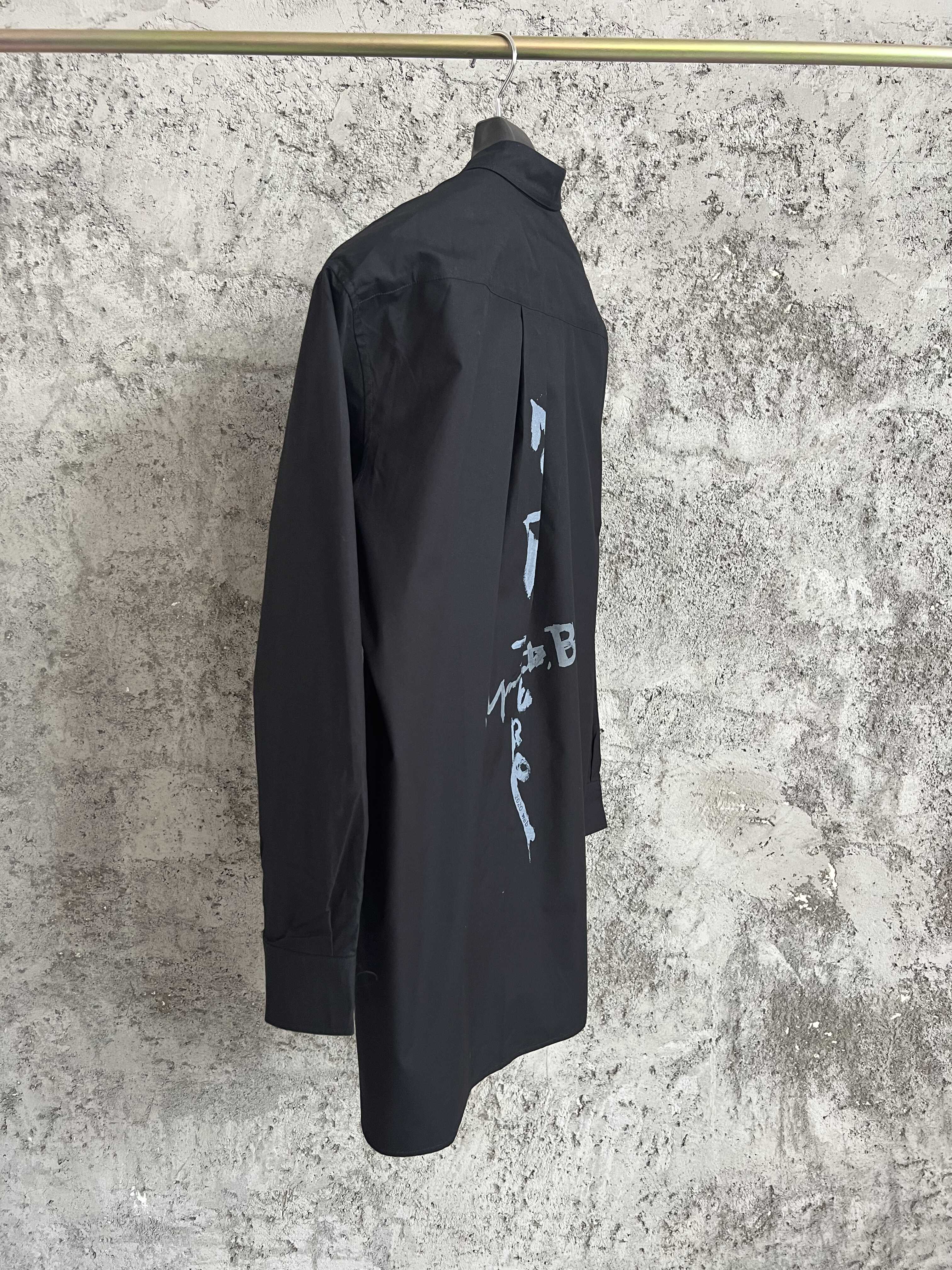 Une simple chemise simple boutonnage à manches longues avec un col double couche, couleur unie et design asymétrique