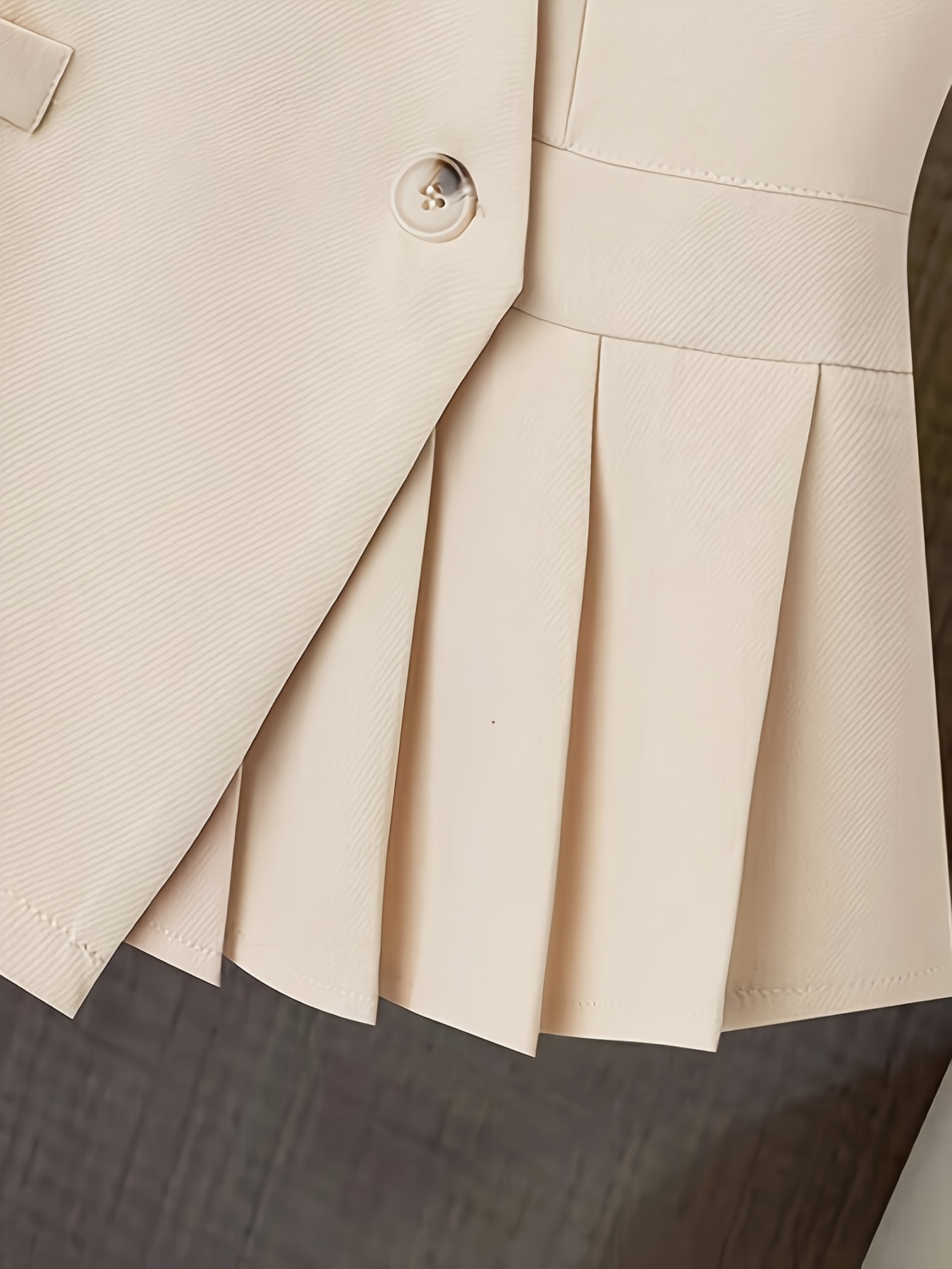 Vêtements pour femmes avec un col en V, un design sans manches et des plis à l'ourlet. Parfait pour les contextes décontractés ou professionnels avec