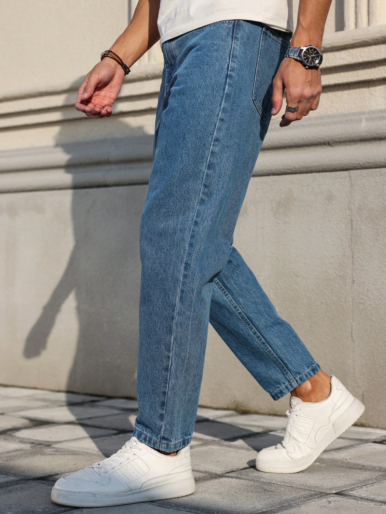 Les jeans pour hommes sont fabriqués en denim bleu classique, à coupe ample, ce qui en fait un vêtement polyvalent indispensable dans la garde-robe.