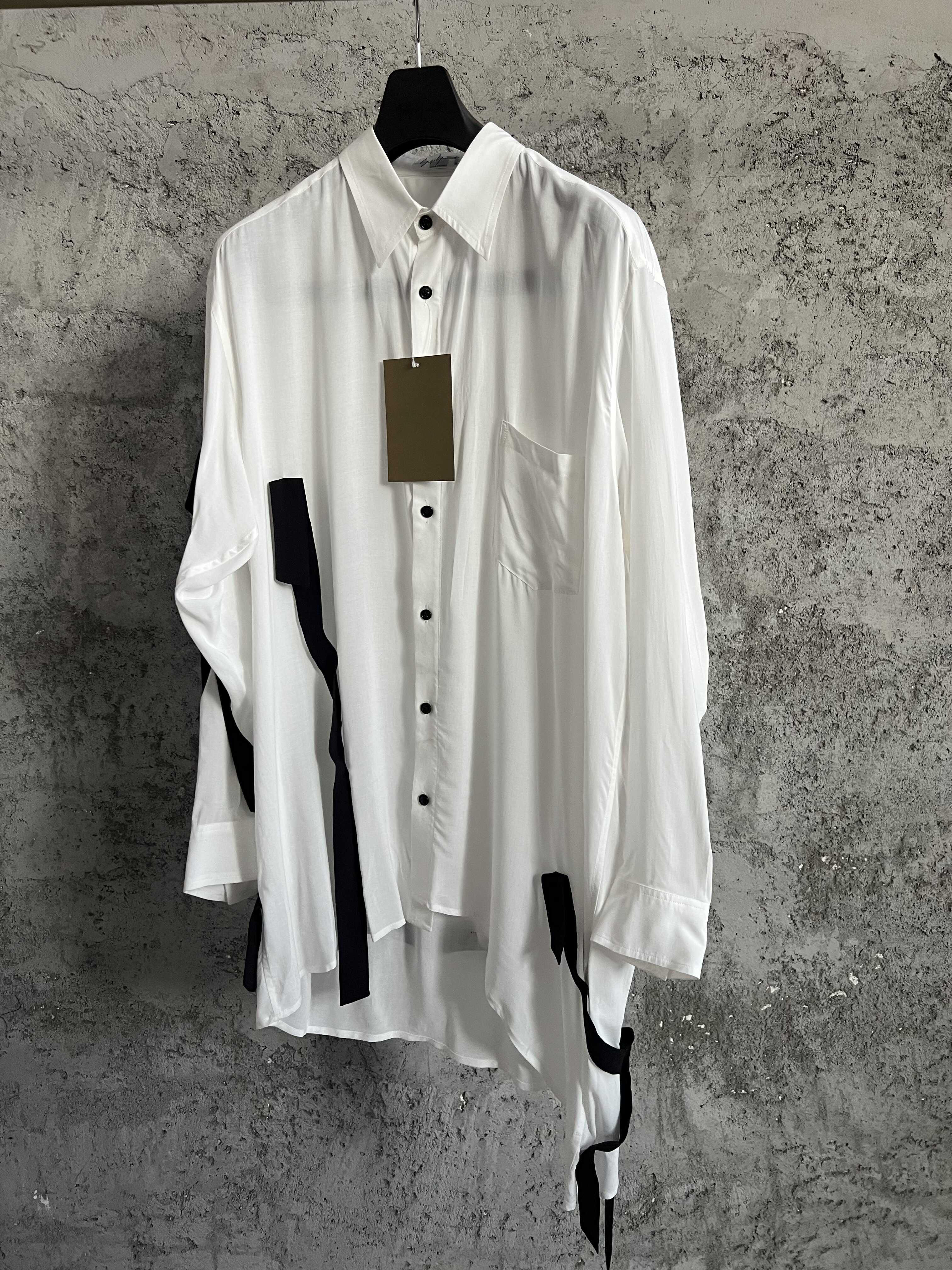 Une chemise avec des lignes de couleurs contrastées, ourlet asymétrique, style ample et fin et haut à simple boutonnage