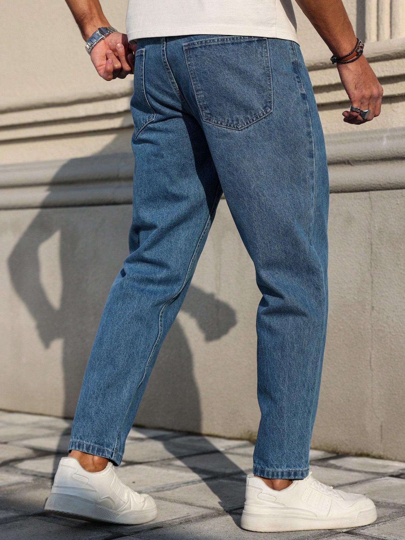 Les jeans pour hommes sont fabriqués en denim bleu classique, à coupe ample, ce qui en fait un vêtement polyvalent indispensable dans la garde-robe.