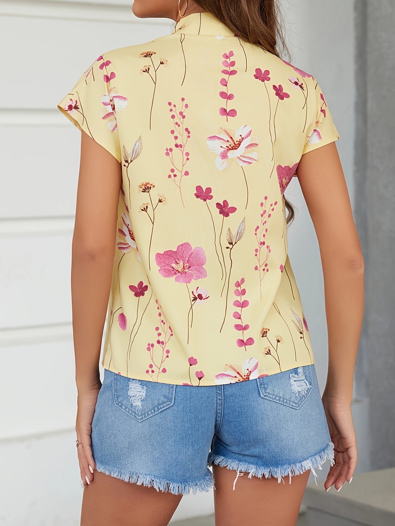 Mode féminine : un design polyvalent à imprimé floral, un haut à manches courtes boutonné à col exquis.
