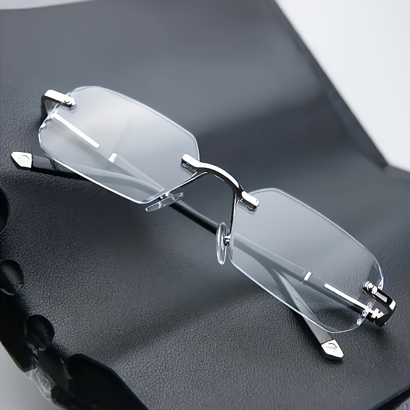 Des lunettes de soleil élégantes, unisexes, sans monture, à verres plats et transparents, au design rectangulaire, pour un usage décontracté.
