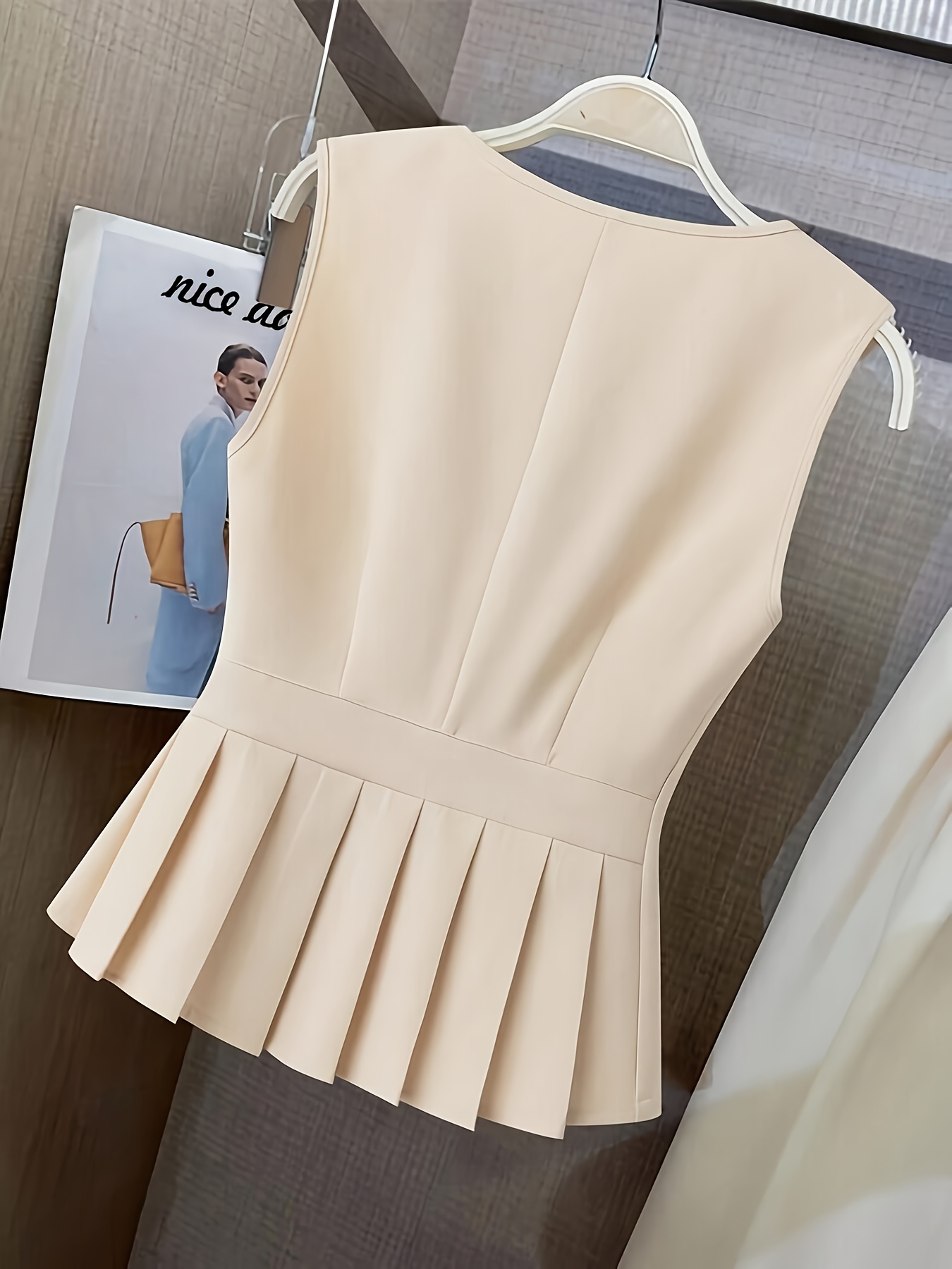 Vêtements pour femmes avec un col en V, un design sans manches et des plis à l'ourlet. Parfait pour les contextes décontractés ou professionnels avec