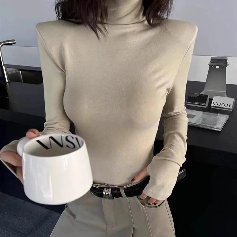 Haut à col montant et manches longues pour femme, nouvelle collection printemps 2026, style coréen minimaliste, design sans revers aux manches, épaules structurées, coupe ajustée, en maille.