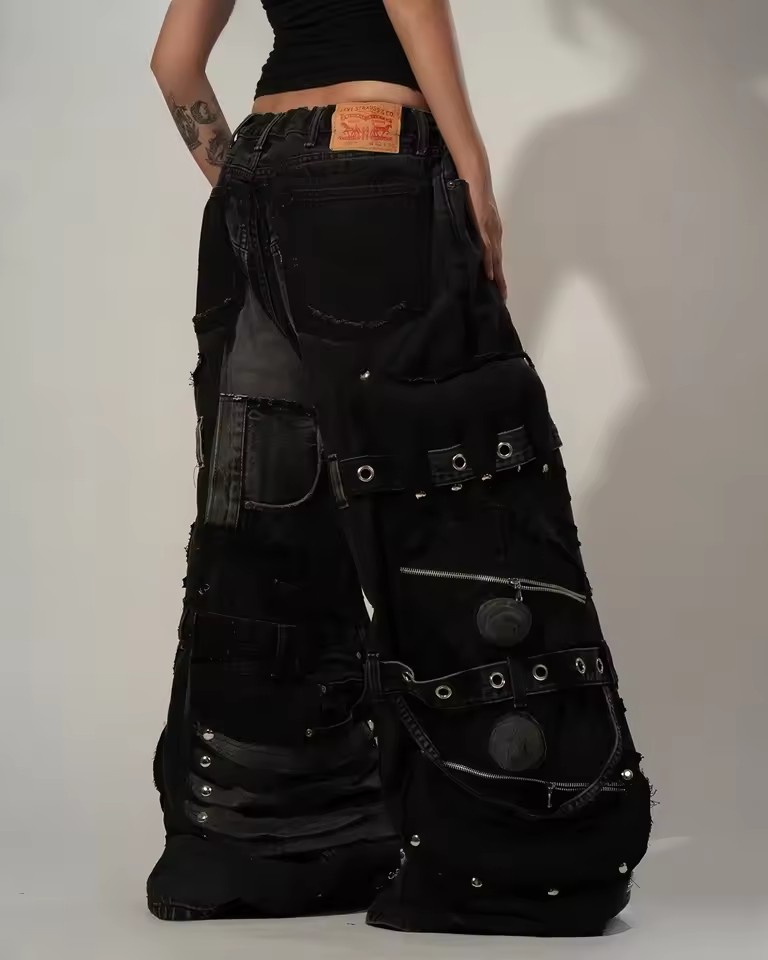 Pantalon en jean noir déchiré unisexe Y2K avec plusieurs poches cargo, bretelles, détails zippés, style punk goth, coupe large et ample, streetwear