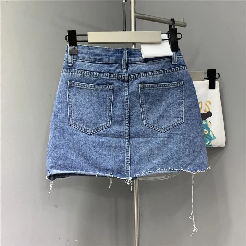 Jupes demi-corps en Denim irrégulier lavé et portées. Nouvelle mode d'été et jupe courte en Denim taille haute individuelle pour femmes