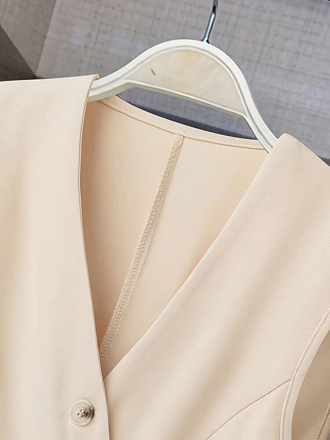 Vêtements pour femmes avec un col en V, un design sans manches et des plis à l'ourlet. Parfait pour les contextes décontractés ou professionnels avec