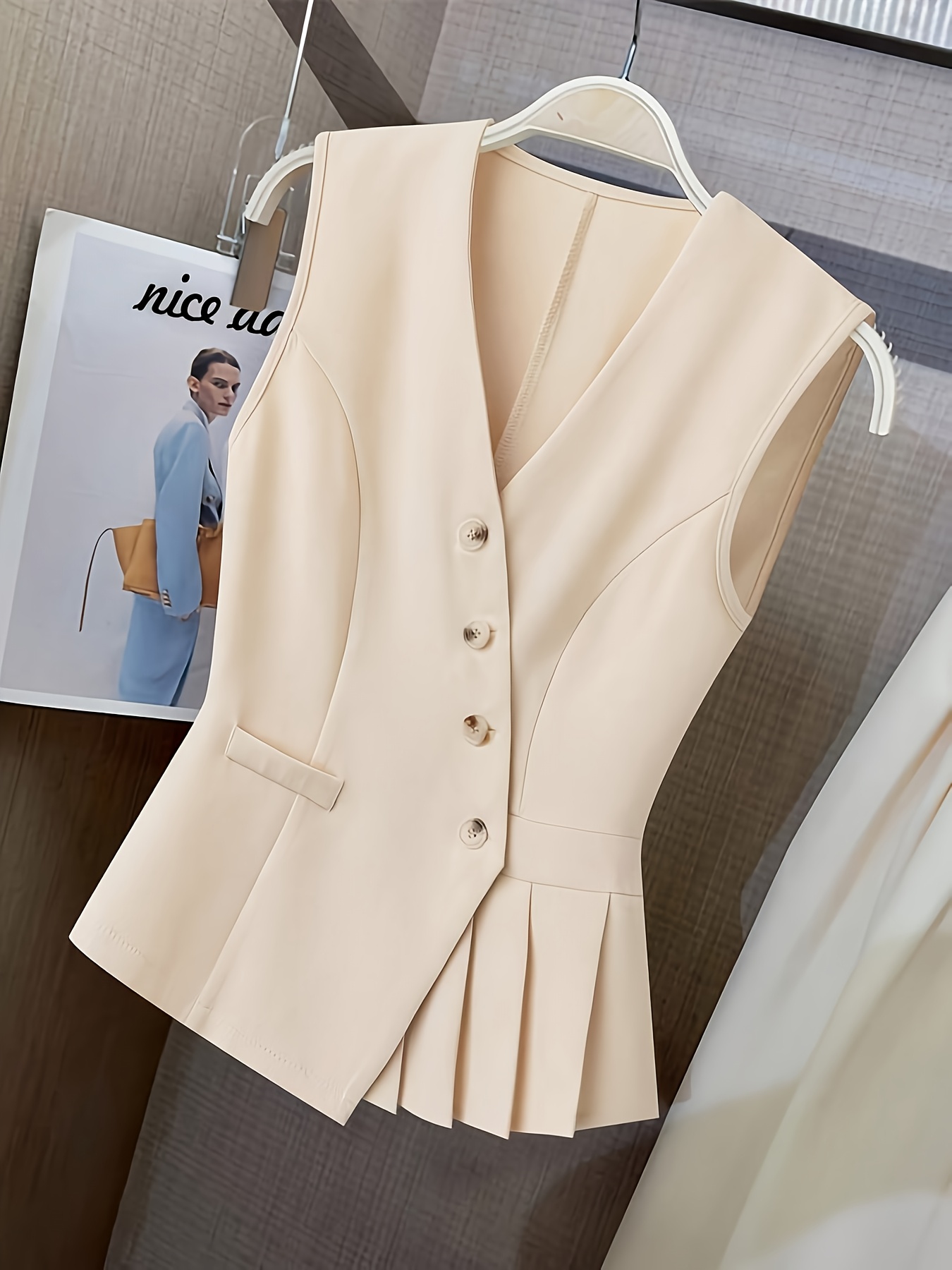 Vêtements pour femmes avec un col en V, un design sans manches et des plis à l'ourlet. Parfait pour les contextes décontractés ou professionnels avec