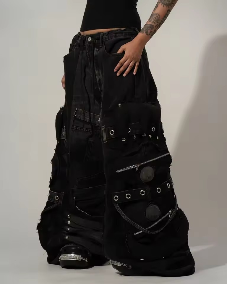 Pantalon en jean noir déchiré unisexe Y2K avec plusieurs poches cargo, bretelles, détails zippés, style punk goth, coupe large et ample, streetwear