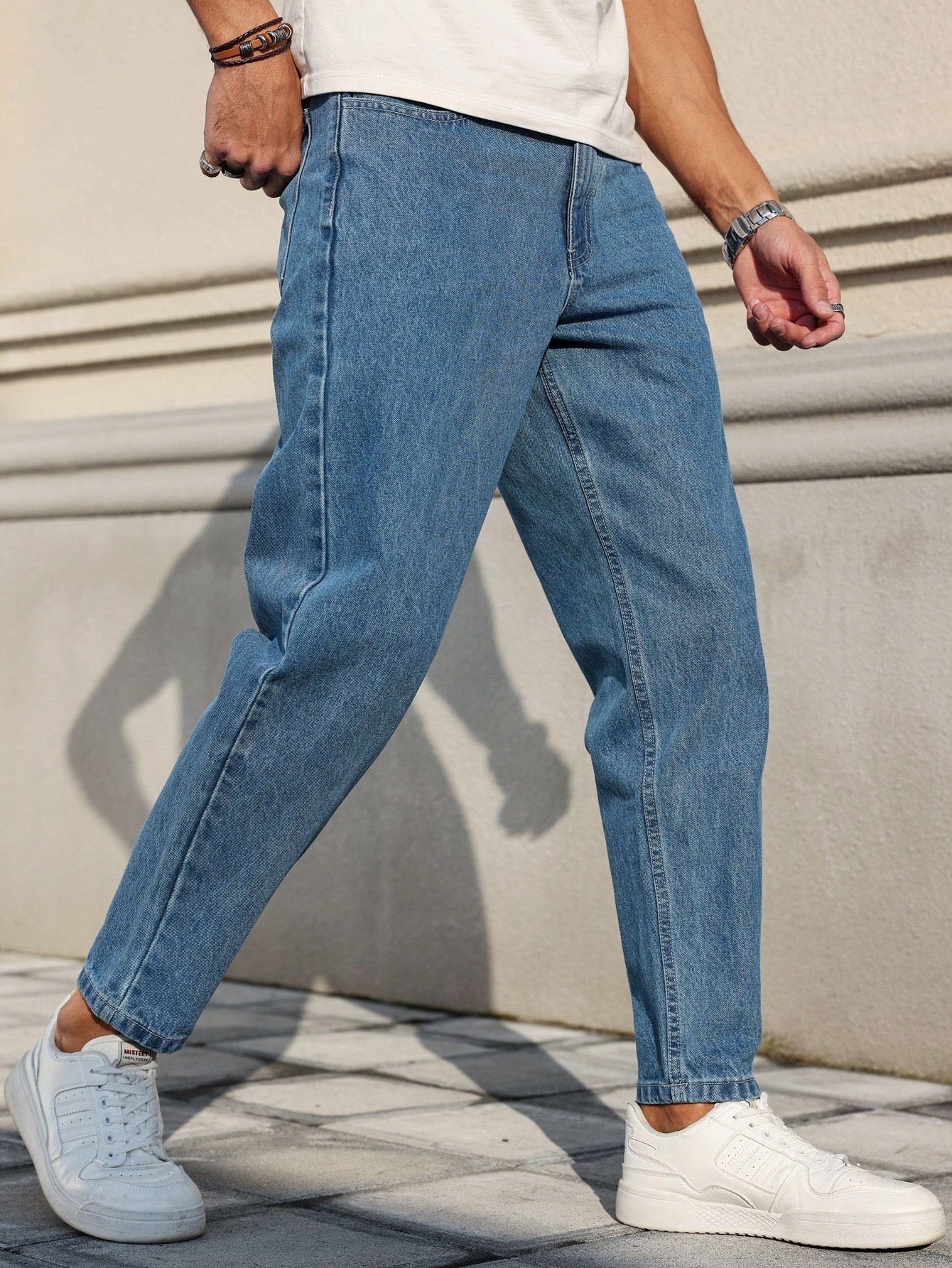 Les jeans pour hommes sont fabriqués en denim bleu classique, à coupe ample, ce qui en fait un vêtement polyvalent indispensable dans la garde-robe.