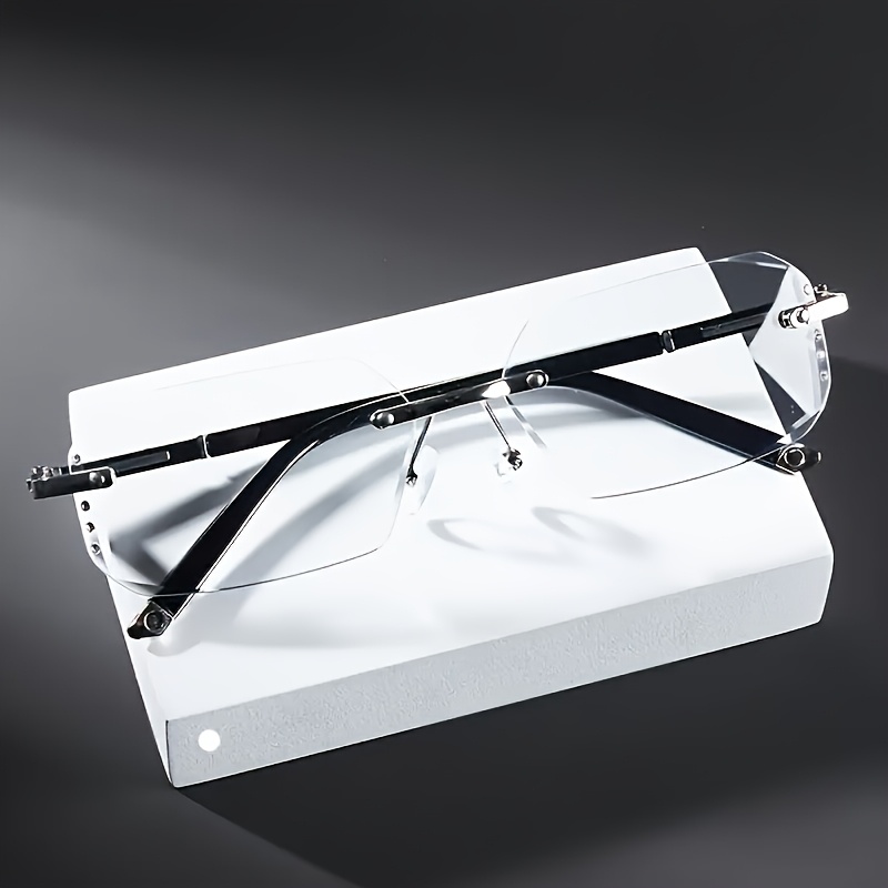 Des lunettes de soleil élégantes, unisexes, sans monture, à verres plats et transparents, au design rectangulaire, pour un usage décontracté.