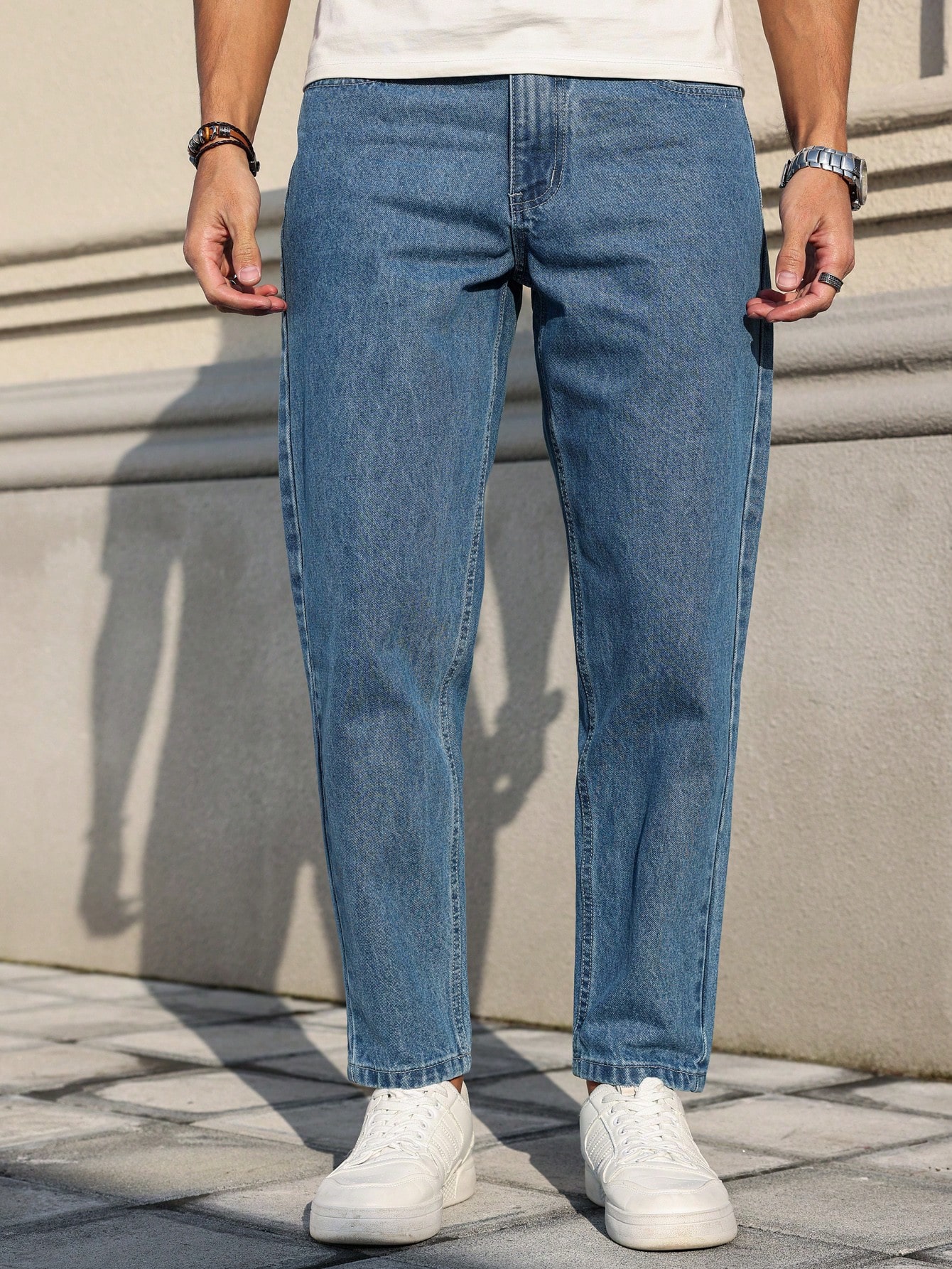 Les jeans pour hommes sont fabriqués en denim bleu classique, à coupe ample, ce qui en fait un vêtement polyvalent indispensable dans la garde-robe.
