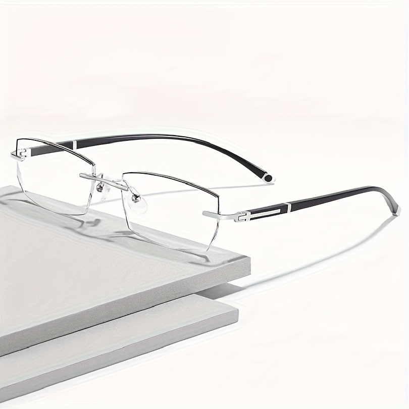 Des lunettes de soleil élégantes, unisexes, sans monture, à verres plats et transparents, au design rectangulaire, pour un usage décontracté.