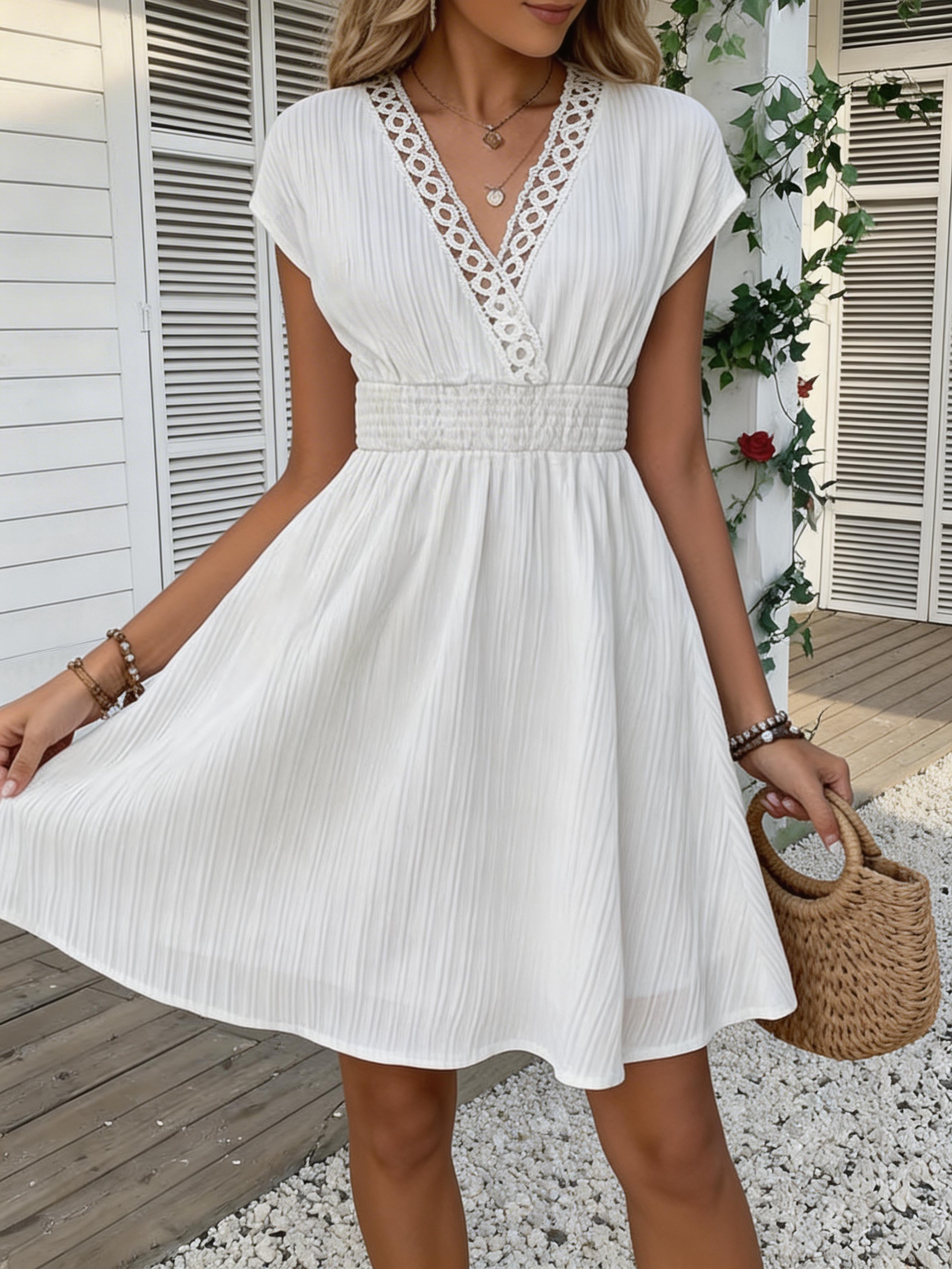 Robe ajustée en dentelle française à col en V avec taille cintrée et manches courtes bouffantes. Jupe courte à texture rayée avec des lignes verticales. Beach-st