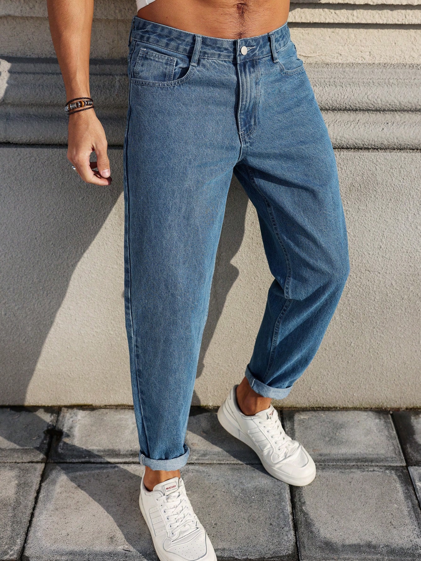 Les jeans pour hommes sont fabriqués en denim bleu classique, à coupe ample, ce qui en fait un vêtement polyvalent indispensable dans la garde-robe.