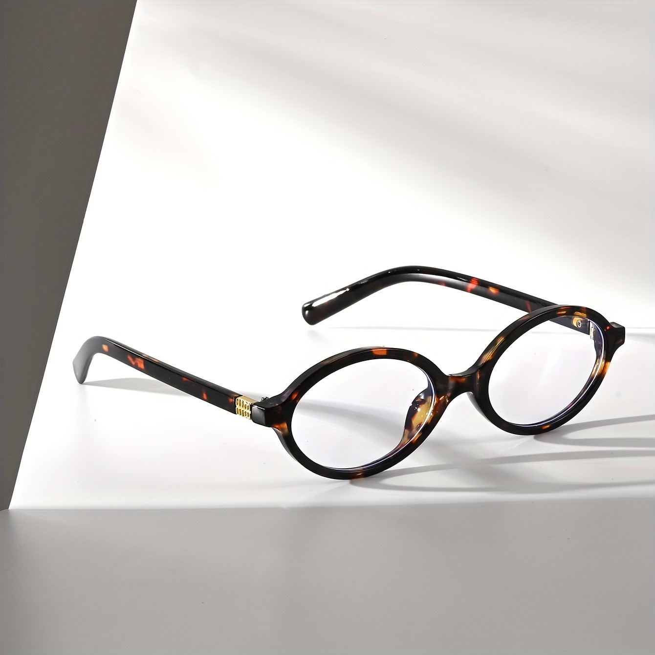 Une paire de lunettes PC ovales rétro pour hommes et femmes, conçues pour les visages fins, polyvalentes pour diverses scènes intérieures.