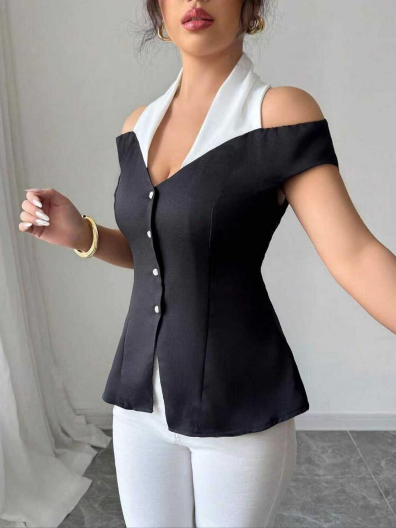 Blouse élégante noire et blanche à blocs de couleur, col halter, épaules dénudées, dos ouvert croisé, taille cintrée boutonnée, coupe ajustée courte pour femme