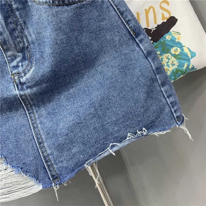 Jupes demi-corps en Denim irrégulier lavé et portées. Nouvelle mode d'été et jupe courte en Denim taille haute individuelle pour femmes