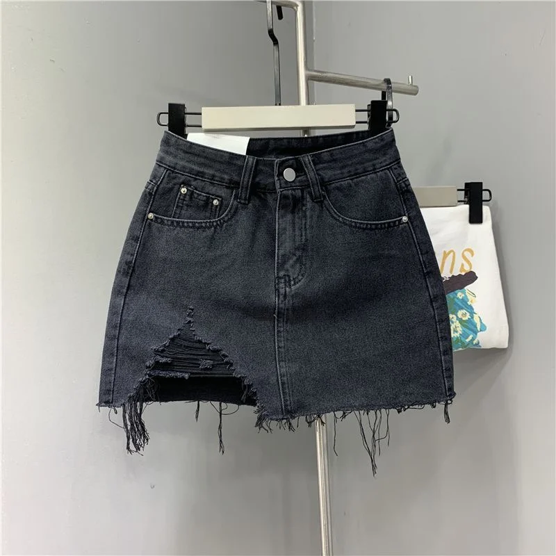 Jupes demi-corps en Denim irrégulier lavé et portées. Nouvelle mode d'été et jupe courte en Denim taille haute individuelle pour femmes