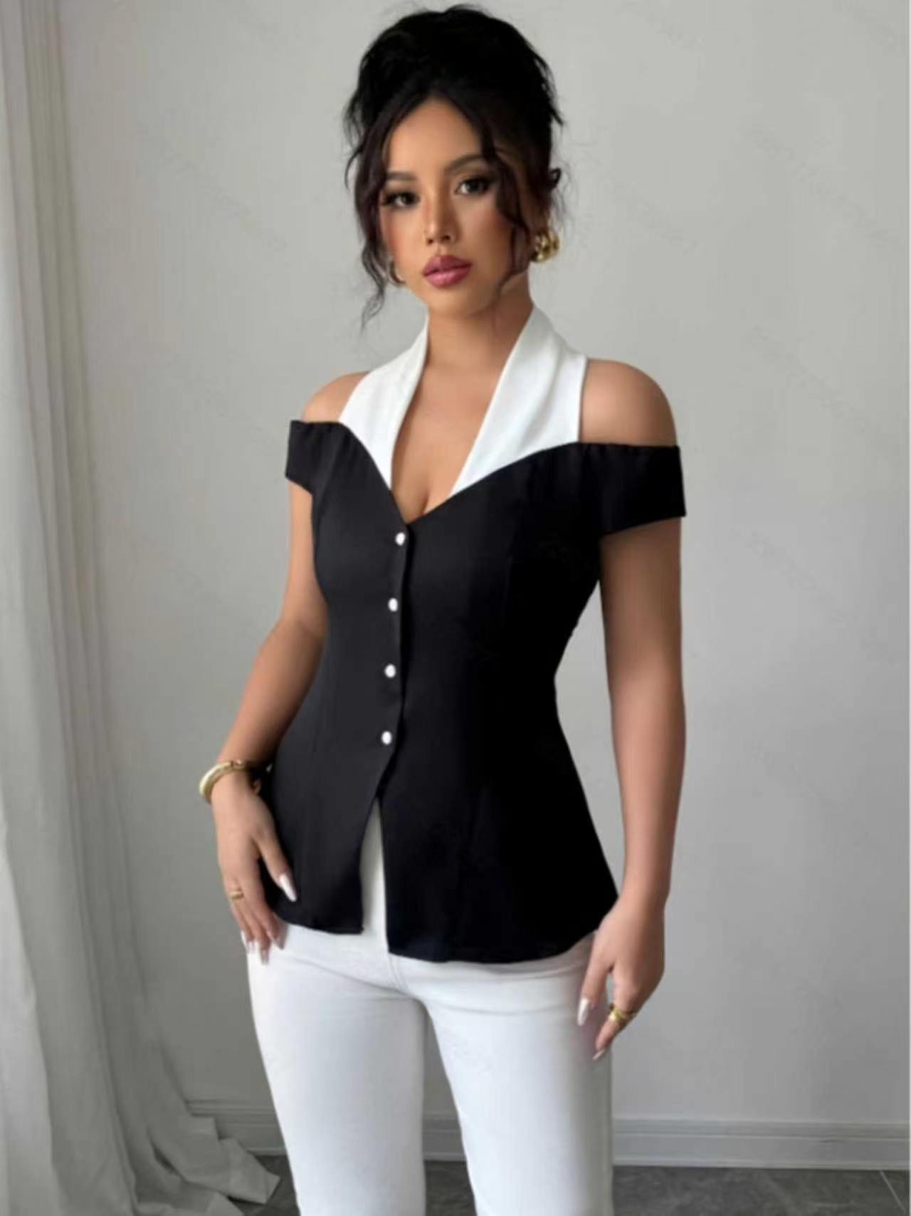Blouse élégante noire et blanche à blocs de couleur, col halter, épaules dénudées, dos ouvert croisé, taille cintrée boutonnée, coupe ajustée courte pour femme