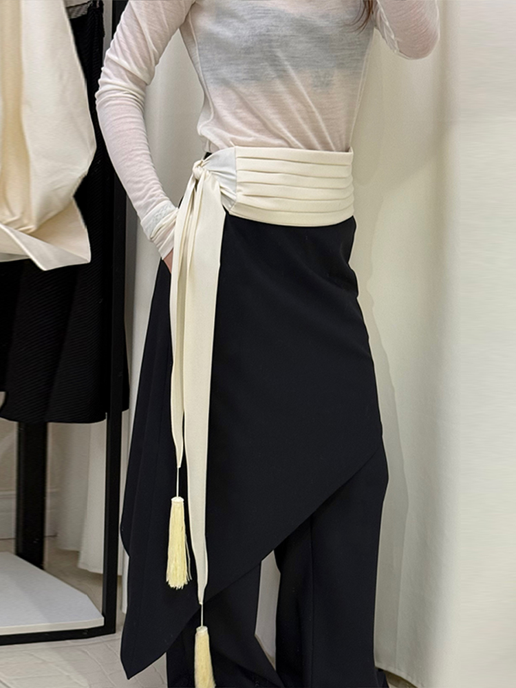 Ceinture à franges et pompons, jupe plissée à contraste de couleurs avec lien latéral et superposition asymétrique, tenue élégante et tendance 2026