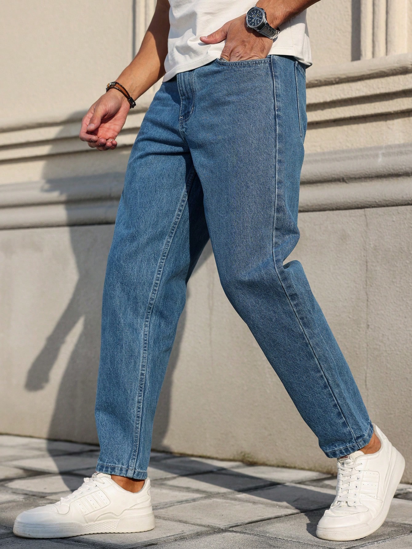Les jeans pour hommes sont fabriqués en denim bleu classique, à coupe ample, ce qui en fait un vêtement polyvalent indispensable dans la garde-robe.