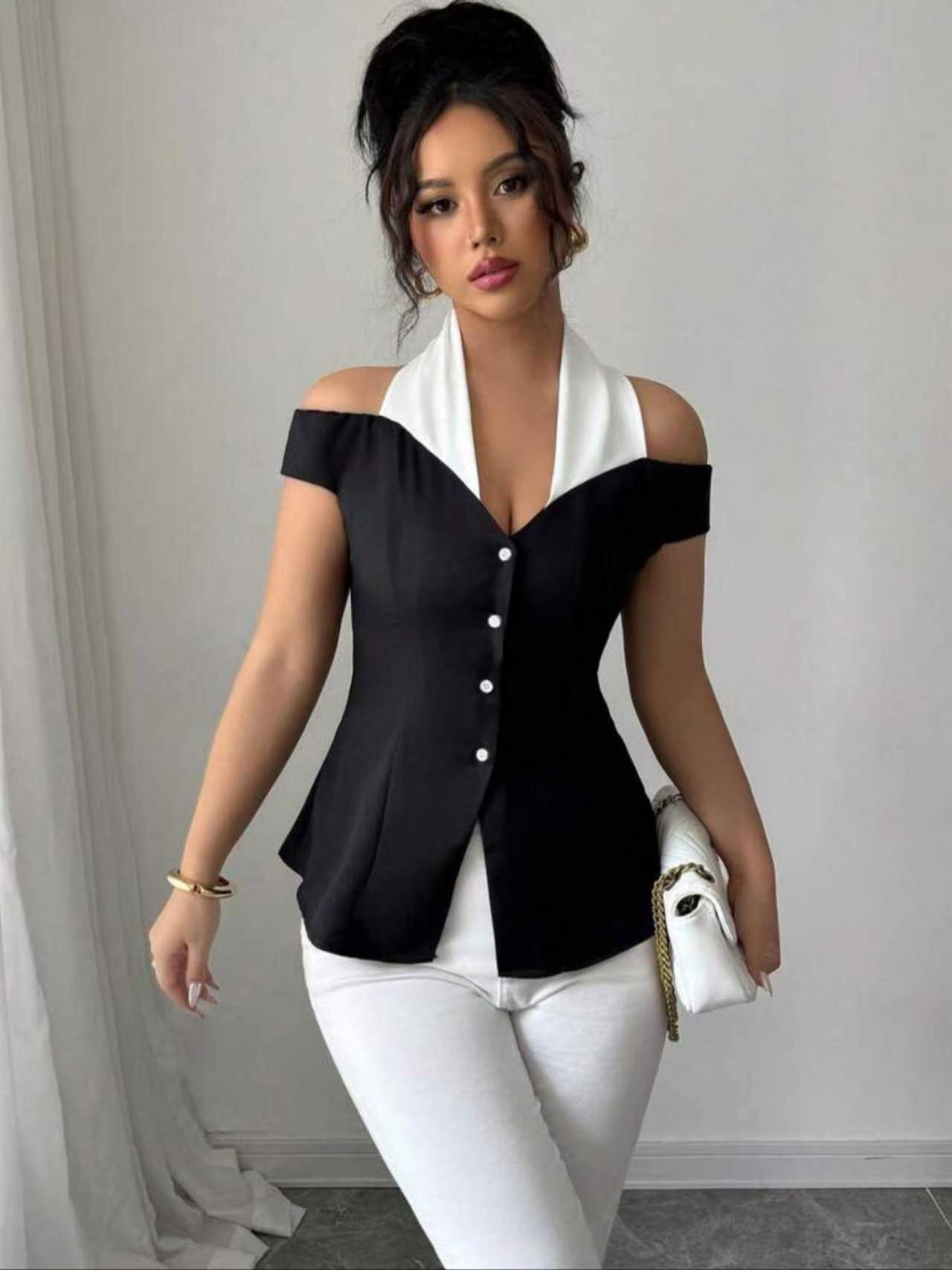 Blouse élégante noire et blanche à blocs de couleur, col halter, épaules dénudées, dos ouvert croisé, taille cintrée boutonnée, coupe ajustée courte pour femme
