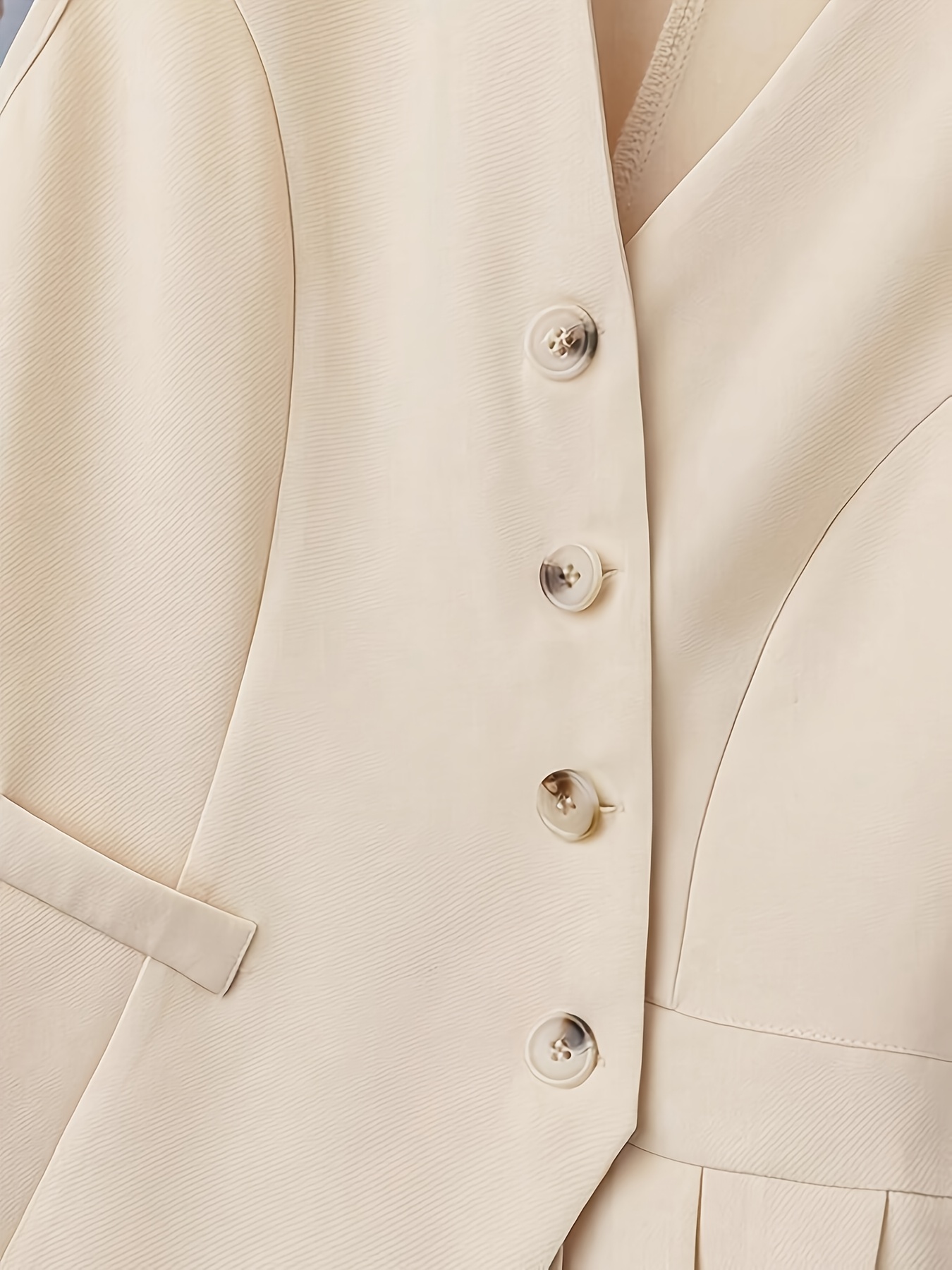 Vêtements pour femmes avec un col en V, un design sans manches et des plis à l'ourlet. Parfait pour les contextes décontractés ou professionnels avec
