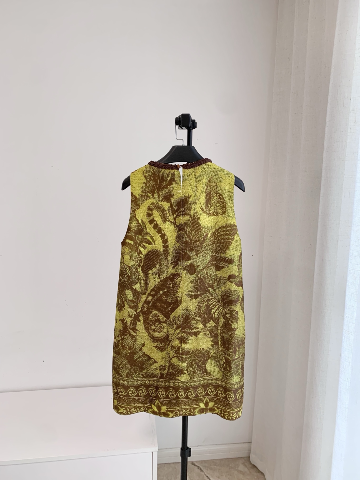Robe courte en soie et lin, sans manches, à col rond, ornée de rubans tissés et d’un motif imprimé.